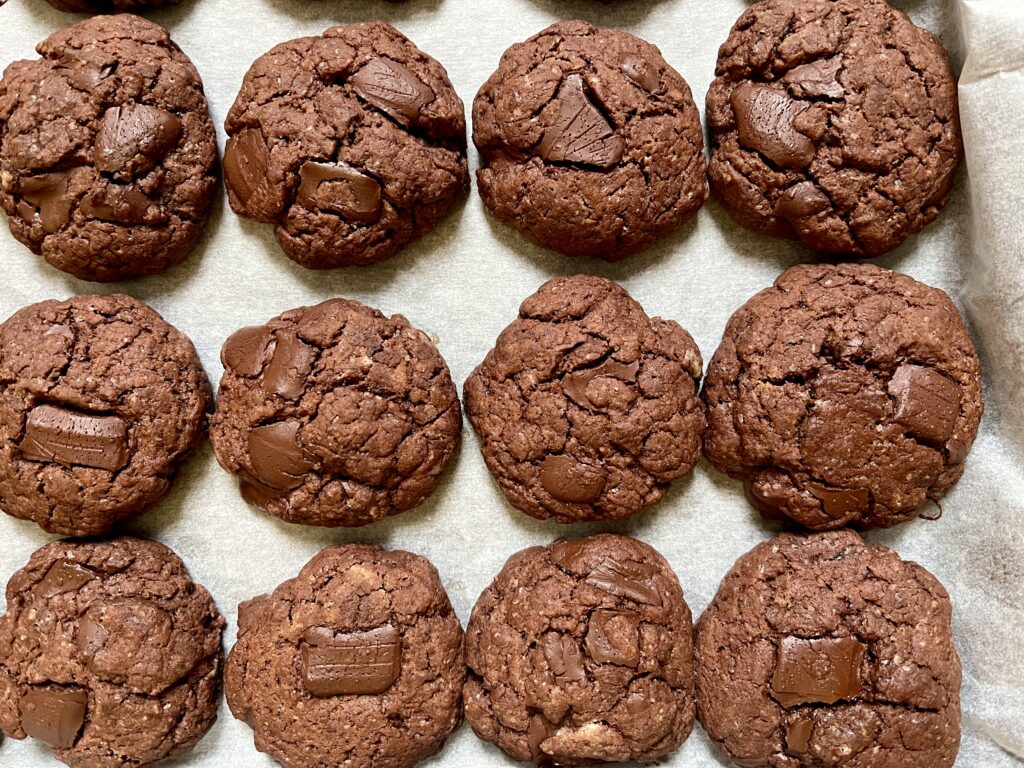 Backblech mit drei Reihen frisch gebackener Schokocookies